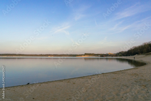Serene lake at dusk with soft sky reflections and tranquil shoreline