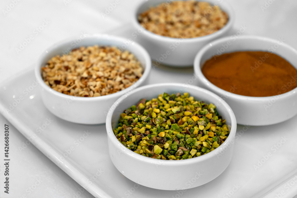 Assorted Ground Nuts and Spices in White Ceramic Bowls – Chopped Pistachios, Hazelnuts, and Cinnamon Powder for Cooking, Baking, Garnishing. High Resolution Food Ingredients Background Assorted Ground Nuts and Spices in White Ceramic Bowls – Chopped Pistachios, Hazelnuts, and Cinnamon Powder for Cooking, Baking, Garnishing. High Resolution Food Ingredients Background