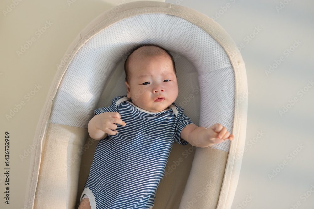 Cute infant napping alone in baby crib
