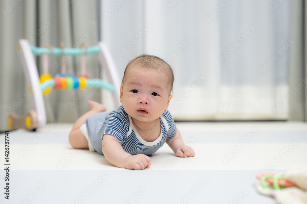 Cute baby lying on soft play mat indoors