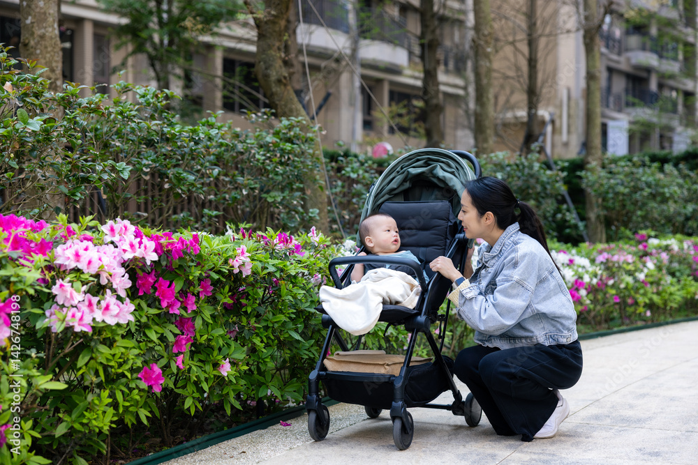 Mother caring for baby in flower garden outdoors