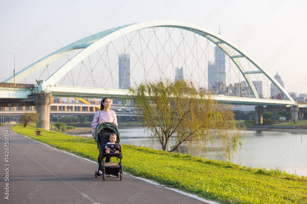 Mum strolling with baby on stroller in Taipei park