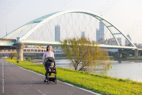 Obraz na płótnie Mum strolling with baby on stroller in Taipei park w salonie
