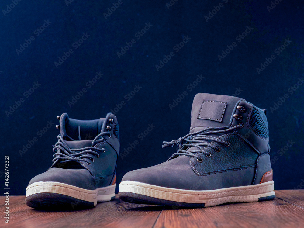 Blue hipsters pair of shoes on wooden table and dark background. Fashion and beauty. Casual footwear.