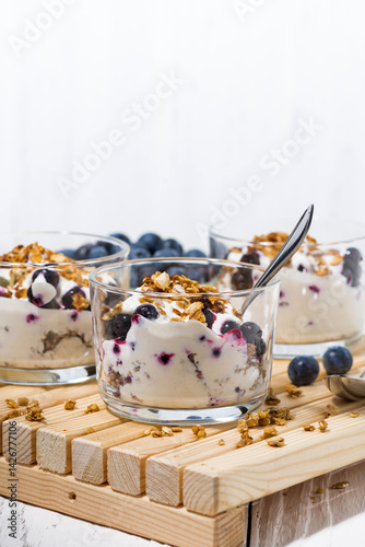 glasses with healthy dessert with blueberries, yogurt and muesli, vertical