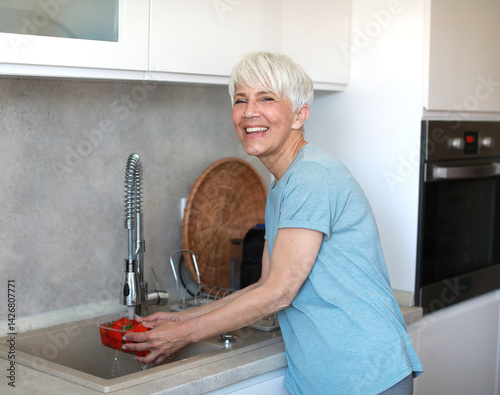 Obraz na płótnie kitchen food woman healthy morning mature fruit water sink washing organic clean hygiene freshness preparation cleaning wash ingredient breakfast active diet home eating w salonie