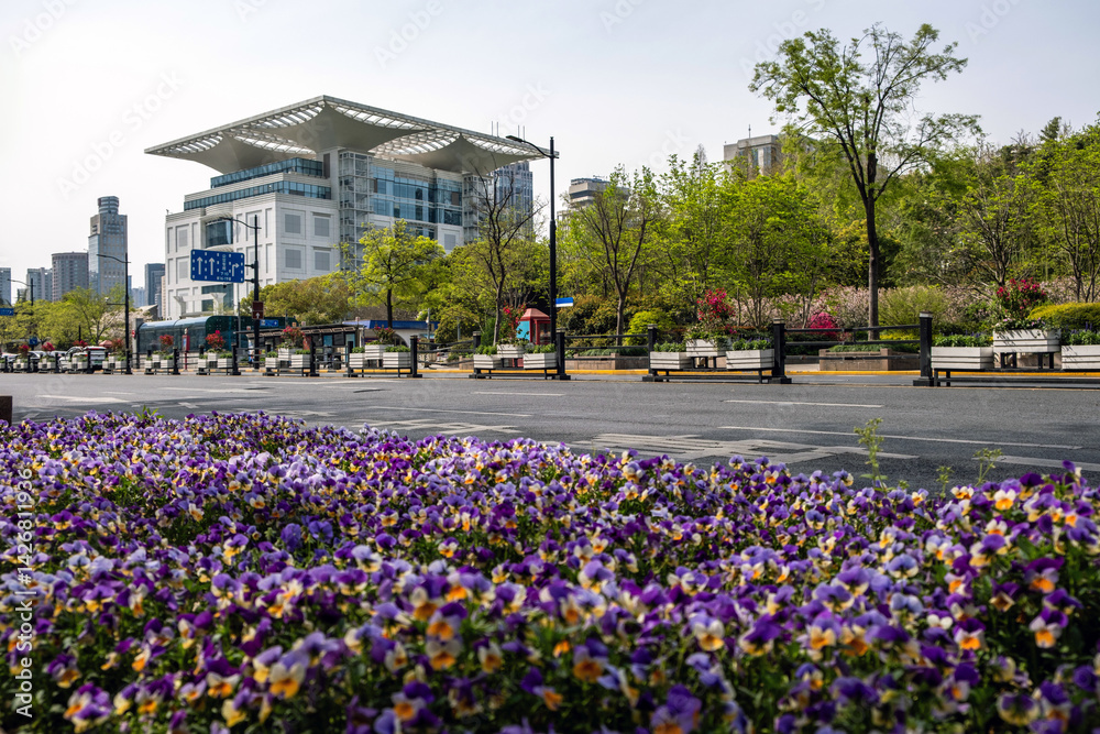Flowerbed on a city street at Shanghai China, modern buildings and cloudy sky
