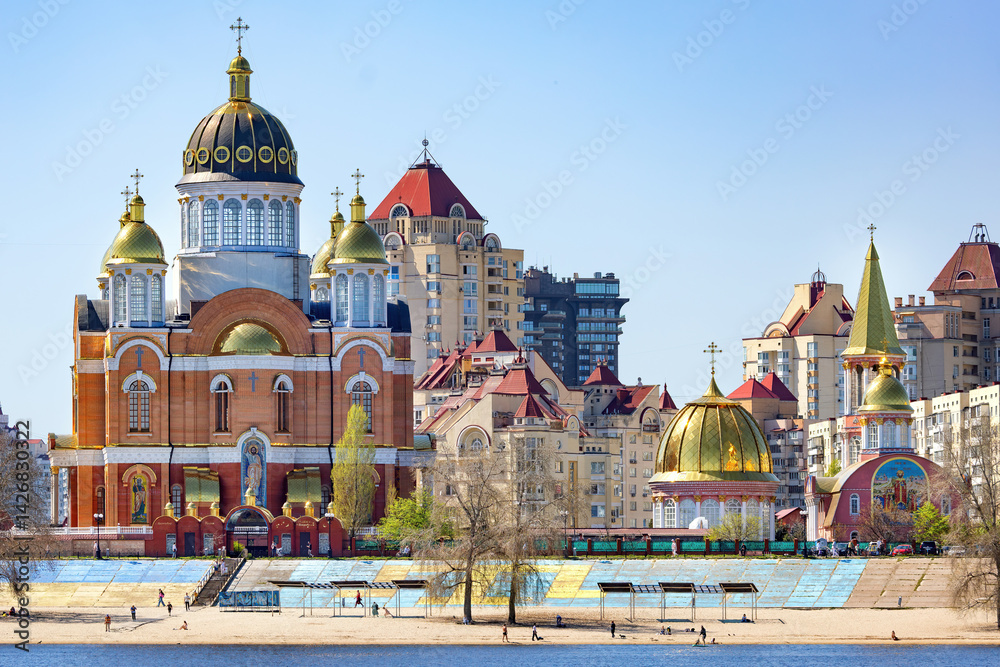 Exploring the vibrant architecture along the riverbank in the urban landscape. An Orthodox church with golden domes.