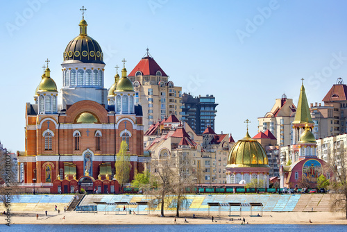 Obraz na płótnie Exploring the vibrant architecture along the riverbank in the urban landscape. An Orthodox church with golden domes. w salonie