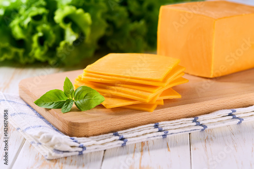 cheddar cheese slices on a light kitchen table, selective focus.