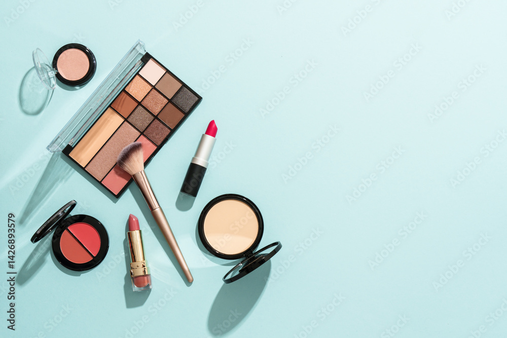 Beauty products for professional make up on blue background. Flat lay.