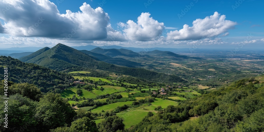 Naklejka premium A beautiful mountain range with a clear blue sky. The mountains are covered in lush green trees and the sky is dotted with clouds. The scene is peaceful and serene, with a sense of calmness