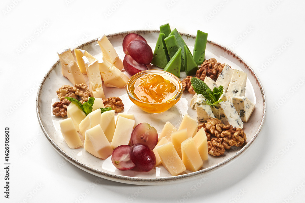 Plate of gourmet cheeses with walnuts, grapes and orange jam