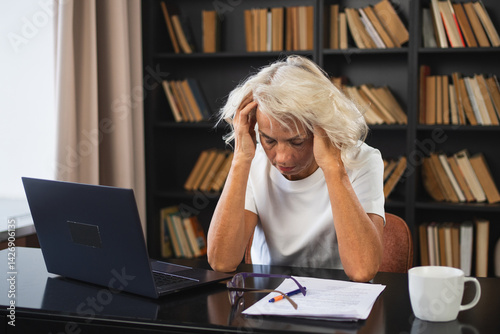 Headache pain. Middle aged woman touching temples experiencing stress. Mature old lady tired of work feeling headache sick rubbing temples forehead. Long laptop usage computer vision office syndrome