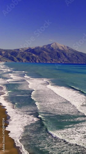 Turquoise waves lapping pristine sandy coastline, mountain silhouette framing tranquil mediterranean seascape with luminous color palette