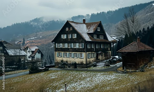 Wintery chalet scene with snow dusted hills and traditional housing