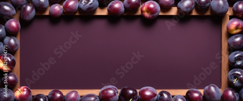 Fresh purple plum fruits on dark. Frame form with copy space, top view