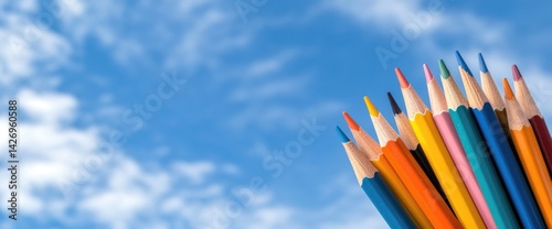 Colored pencils against blue sky creative arts education supplies