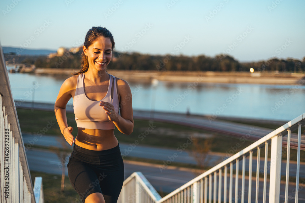 Woman Jogging Outdoors on Stairs by a Scenic Waterfront
