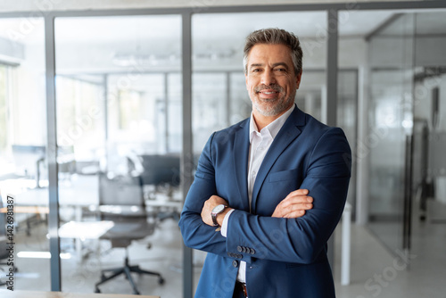Portrait of indian or latin hispanic mature middle age boss, leader, ceo male businessman in suit in office workplace. Executive confident senior business man specialist looking at camera. Copy space