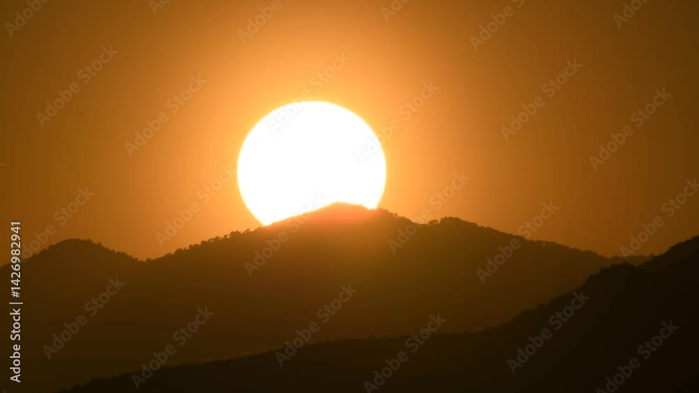 Sunset over mountains. Time-lapse sunset Mountains illuminated by the sun. The sun sets over the hills. Mountain silhouette at sunset Sunset over mountains. Time-lapse sunset Mountains illuminated by the sun. The sun sets over the hills. Mountain silhouette at sunset