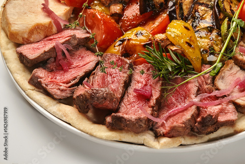 Obraz na płótnie Sliced grilled beef tenderloin with grilled vegetables and pita bread w salonie
