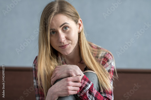 Young Woman Relaxing Indoors While Wearing a Checkered Shirt