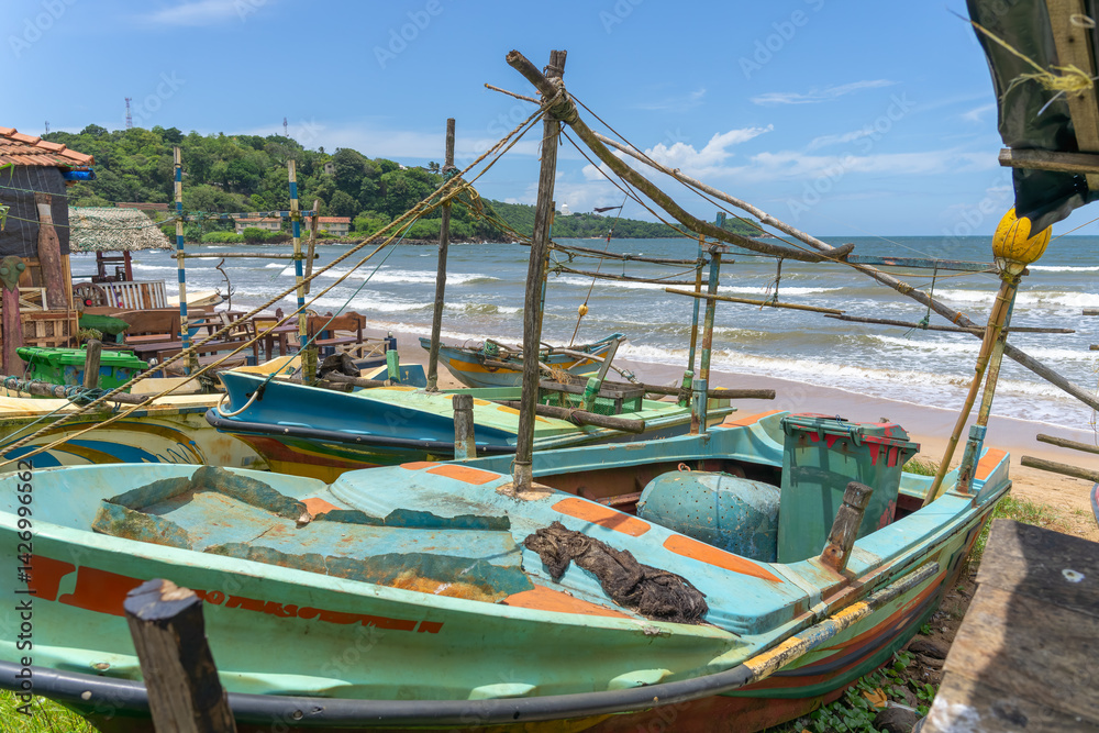 Fototapeta premium Old fishing boats pulled up on beach near Galle Sri Lanka
