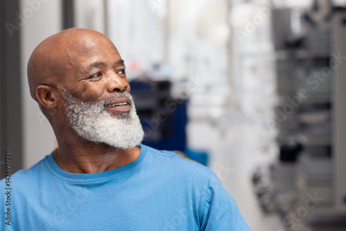 Obraz na płótnie Senior African American man smiling gently and looking at lab equipment in indoor lab setting w salonie