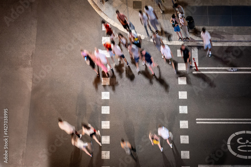 pedestrians crossing the street at night. Blurred top view of people walking