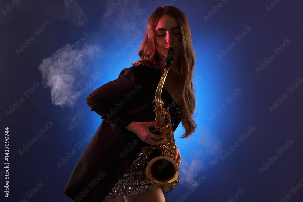 Obraz premium Professional musician playing saxophone on color background with smoke