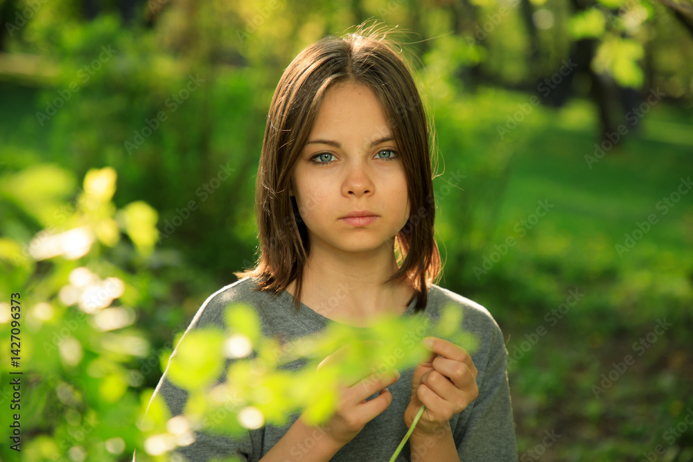 Portrait of preteen girl in park in spring.