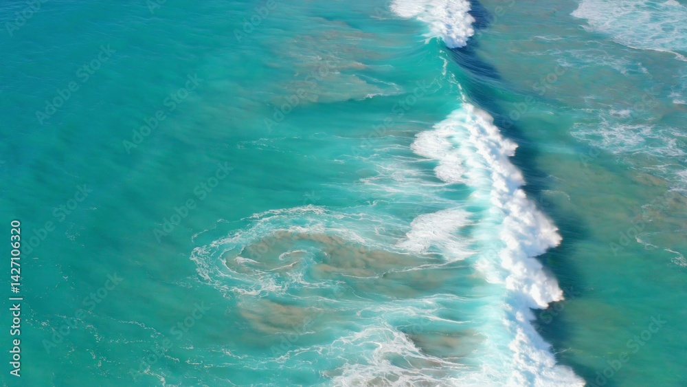 Aerial view showing coral and sandy sea bottom, with ocean water above. Natural beauty under the sea.