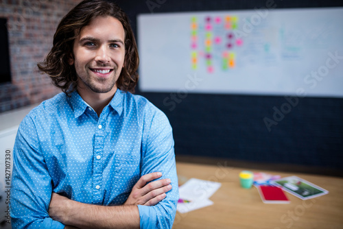 Obraz na płótnie Man standing crossing arms and smiling in modern office, with whiteboard and coffee cup w salonie