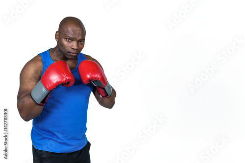 Obraz na płótnie African American man throwing punches in photo studio wearing red gloves blue tank top black shorts w salonie