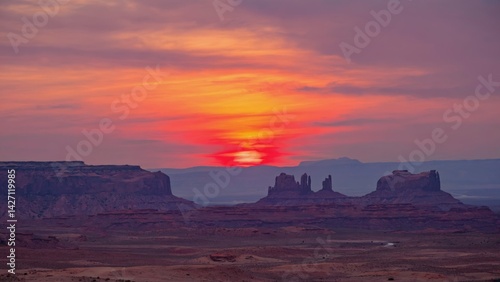 Obraz na płótnie The sun is setting on the mesa, casting a warm glow over the landscape. The red rocks are bathed in hues of orange and pink, indicating the end of the day. w salonie