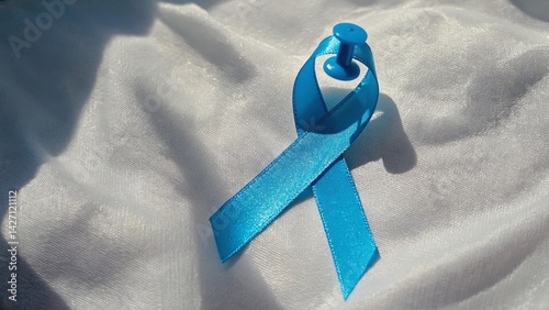 Obraz na płótnie A blue awareness ribbon, often worn to show support or raise awareness for various causes. This symbolizes solidarity and hope in the face of challenges. w salonie