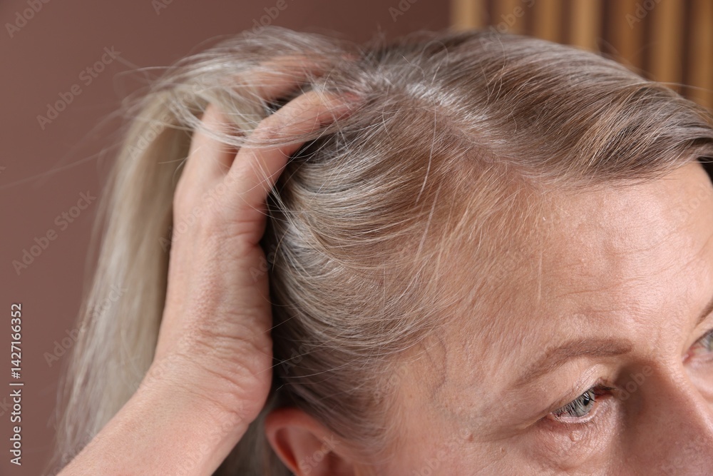 Fototapeta premium Senior woman with healthy hair roots on blurred background, closeup