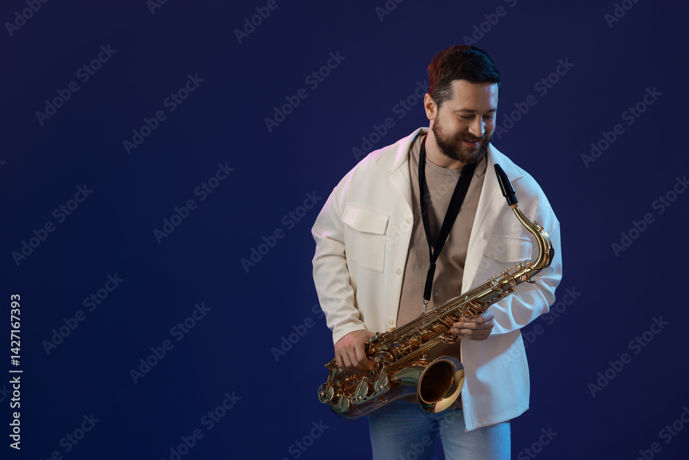 Naklejka premium Professional musician with saxophone on blue background. Space for text