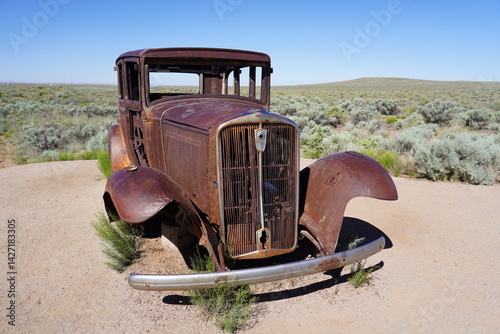 A vintage car sits on Route 66 at Petrified Forest National Park in Arizona, USA