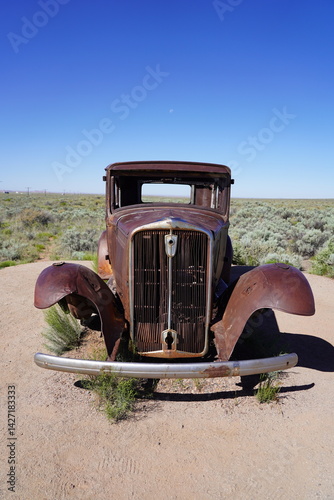 A vintage car sits on Route 66 at Petrified Forest National Park in Arizona, USA