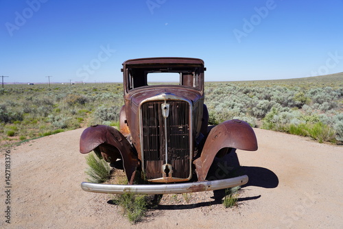 A vintage car sits on Route 66 at Petrified Forest National Park in Arizona, USA