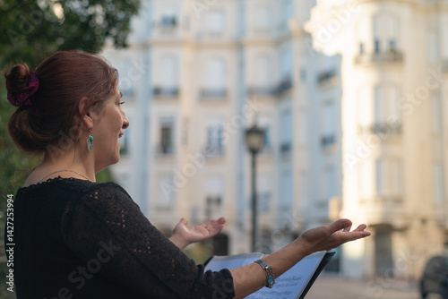 Foto Mature woman singing outdoors, accompanied by a music stand.