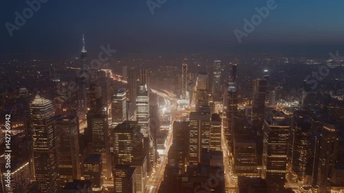 Wallpaper Mural Aerial view of a sprawling metropolis at dusk, featuring illuminated skyscrapers, office buildings, and bright highway traffic. Torontodigital.ca