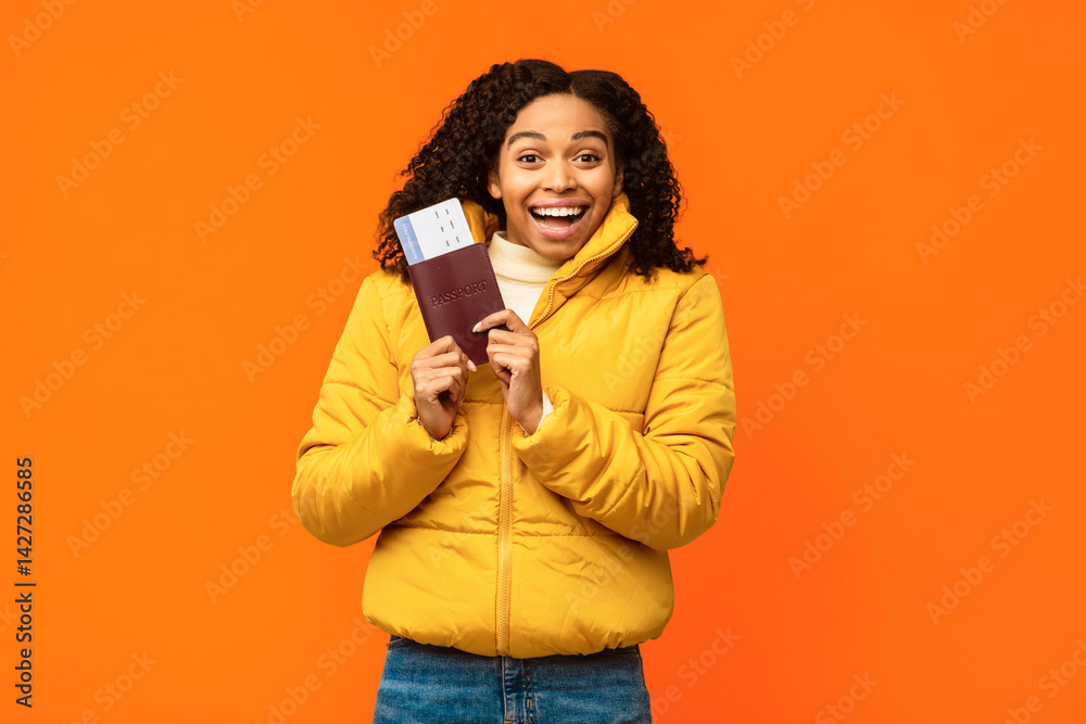 Obraz premium Joyful African American Traveler Woman Holding Flight Tickets Smiling To Camera Standing Over Yellow Studio Background. Winter Travel And Vacation, Tourism Concept