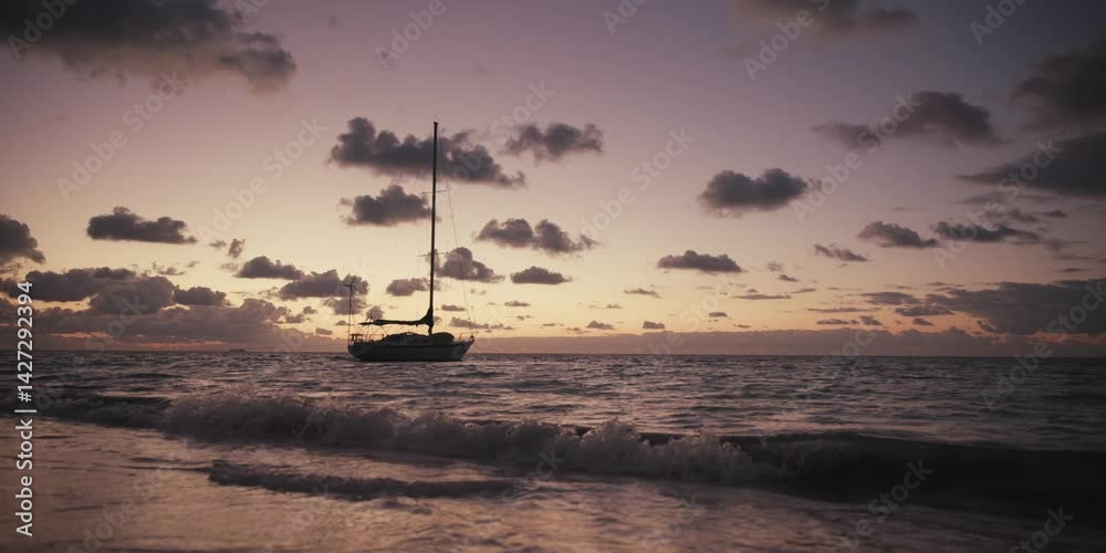Contraluz de un velero a la orilla del mar al amanecer, hermoso amanecer en la costa con la silueta de un velero de fondo