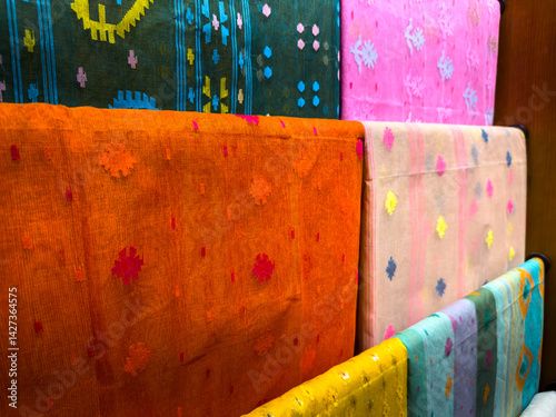 Vibrant Jamdani saris, a UNESCO-recognized heritage textile of Bangladesh, are beautifully displayed for sale at a local market. Known for intricate handwoven patterns and cultural significance