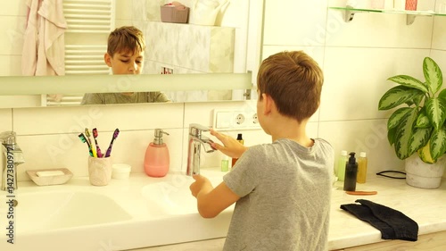 Boy is making morning routine - washing face