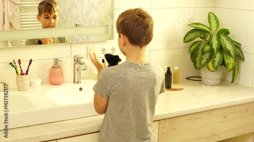 Boy is making morning routine - washing face