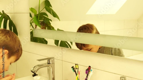 Boy is making morning routine - washing face